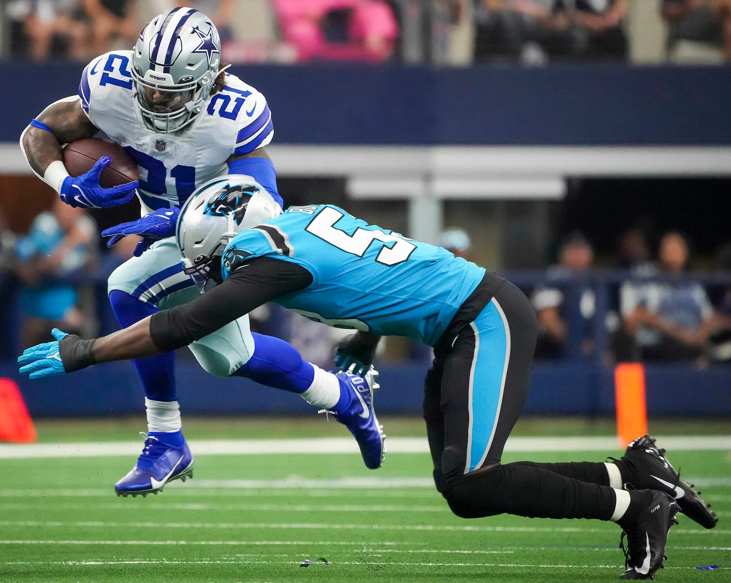 Dallas Cowboys running back Ezekiel Elliott (21) is brought down by Carolina Panthers...