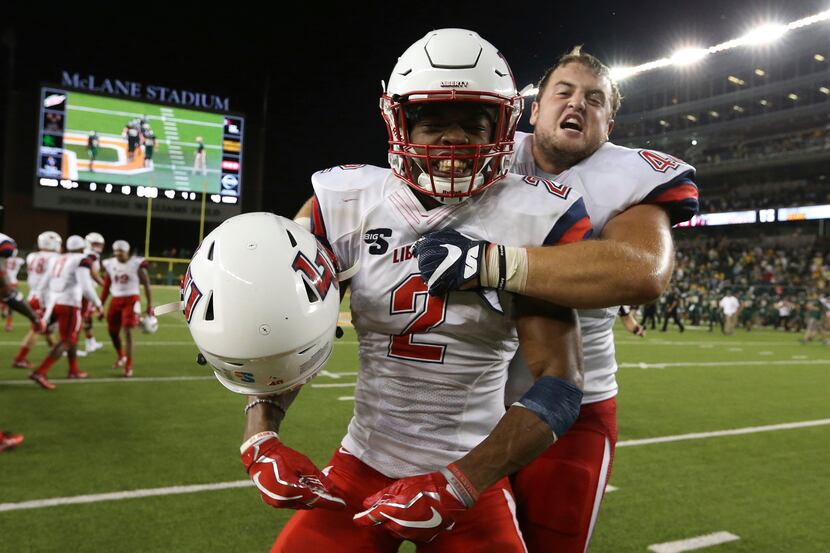 Liberty tight end Zac Foutz, right, hugs cornerback Jeremy Peters, left, following their...