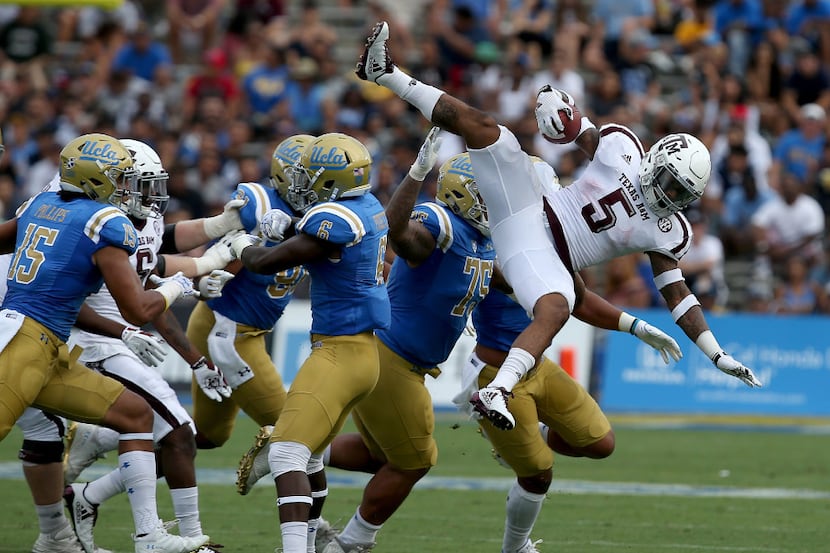 Texas A&M running back Trayveon Williams gets airborne trying to get extra yardage against...