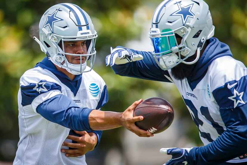 Dallas Cowboys quarterback Dak Prescott (4) hands off to running back Ezekiel Elliott (21)...