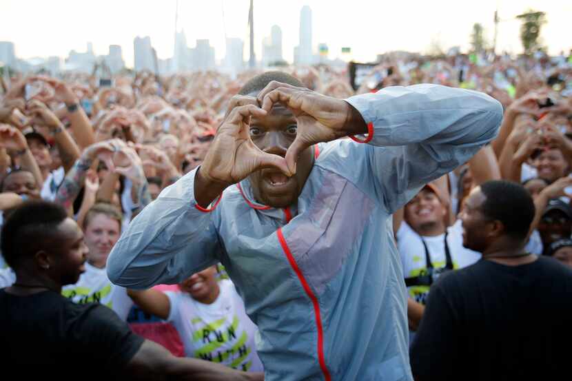 Kevin Hart signals a heart to the people before running in the Local Run With Hart running...