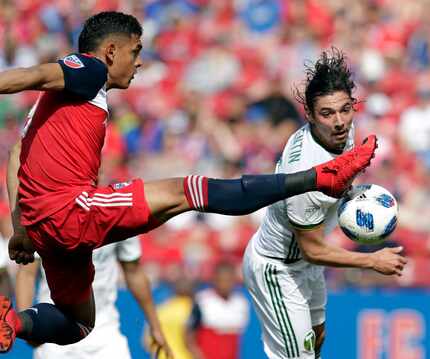 FC Dallas forward Cristian Colman, left, attempts to deflect a shot into the net that...