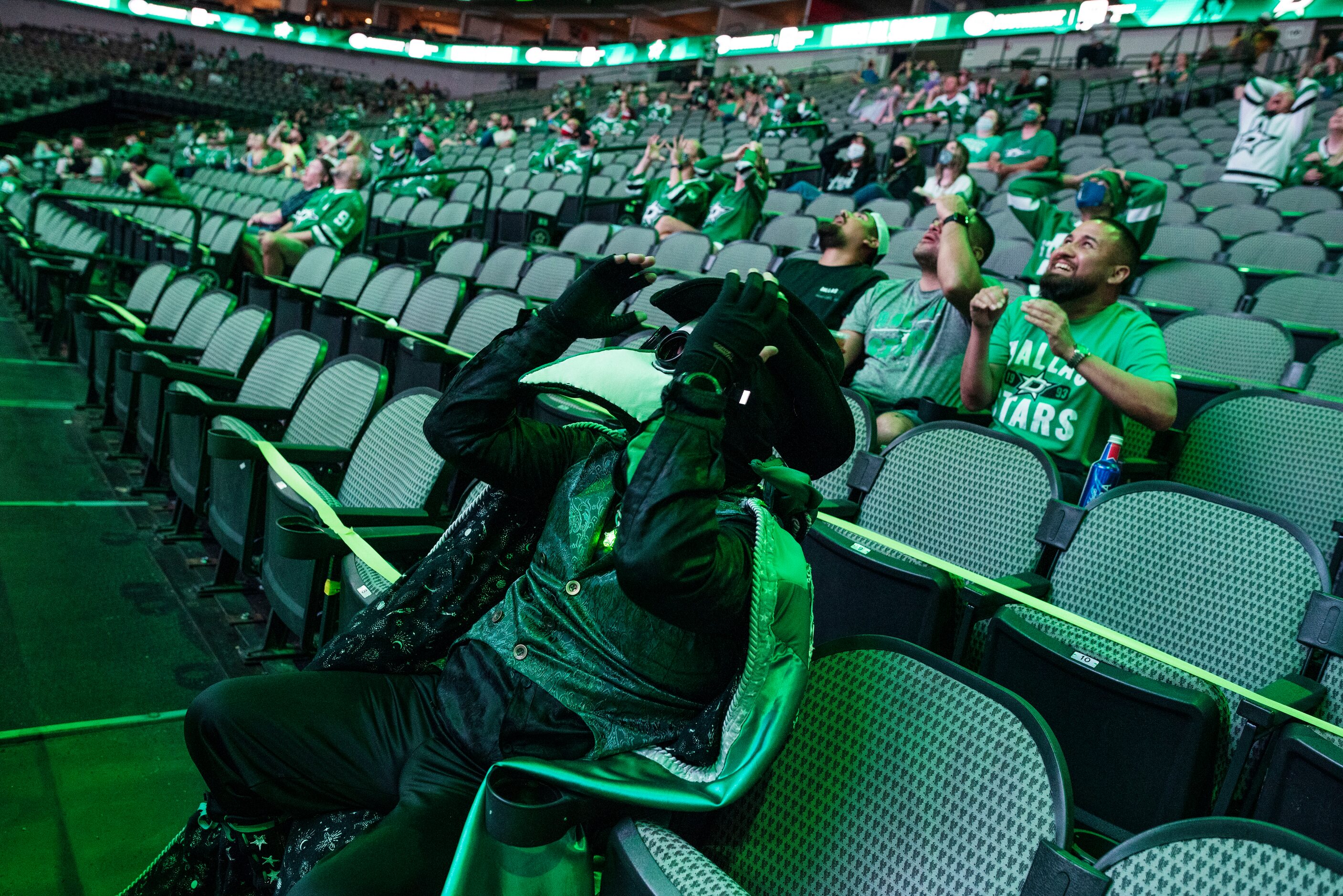 Matt Day, 46, touches his costume mask as he reacts while watching the Dallas Stars against...