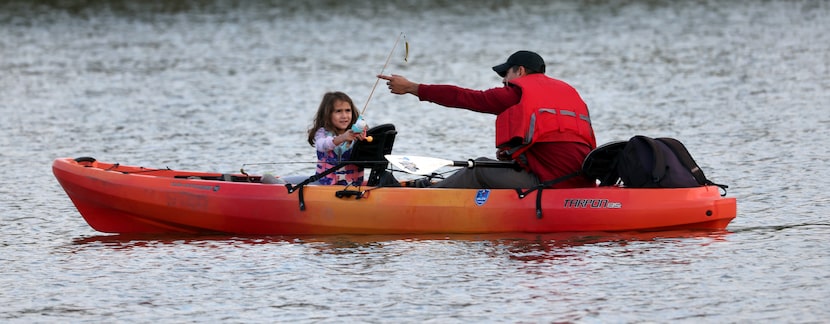 U.S. Army veteran Eric Chacon and his daughter Isabella fish from a tandem kayak during an...