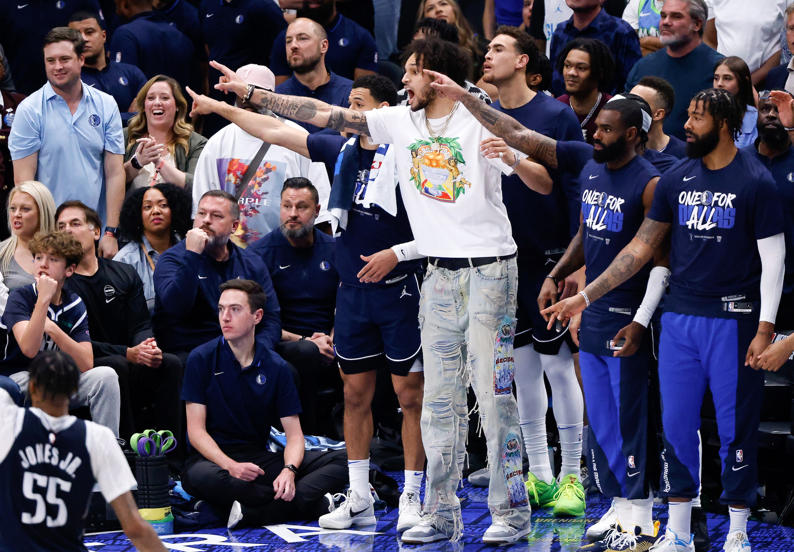 Injured Dallas Mavericks center Dereck Lively II (white t-shirt) yells at a call with his...