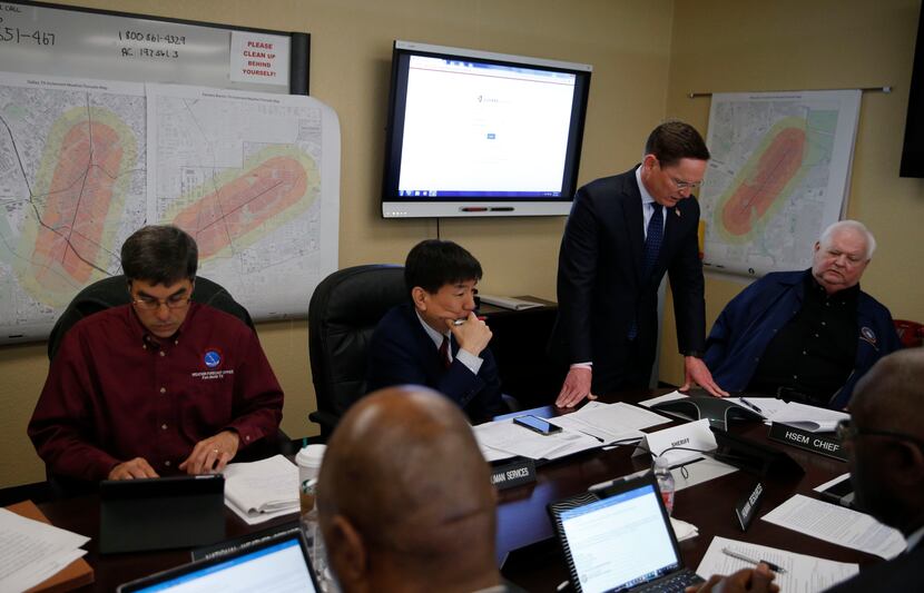 Dallas County Judge Clay Jenkins (standing) talks on a conference call in the policy room...