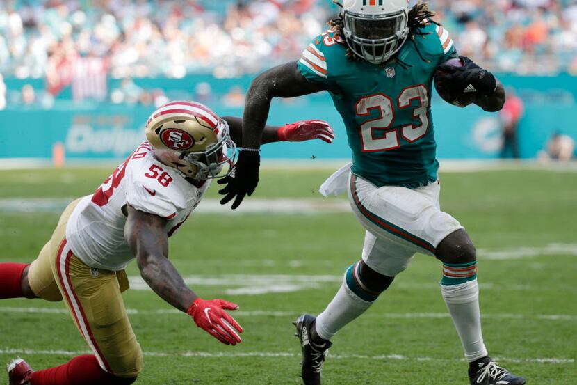 FILE - In this Nov. 27, 2016, file photo, Miami Dolphins running back Jay Ajayi (23) runs...