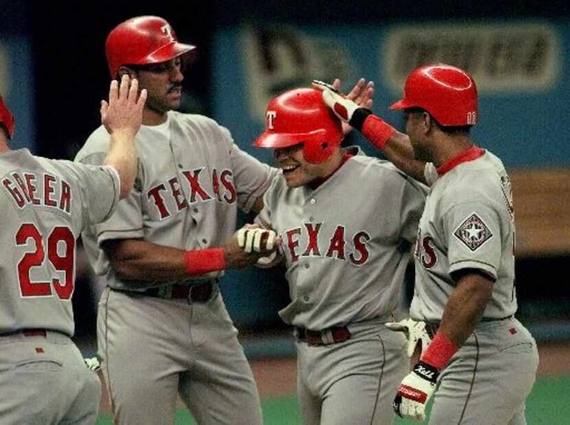 ORG XMIT: S116513B3_WIRE Texas Rangers' Ivan Rodriguez, second right, is greeted at the...