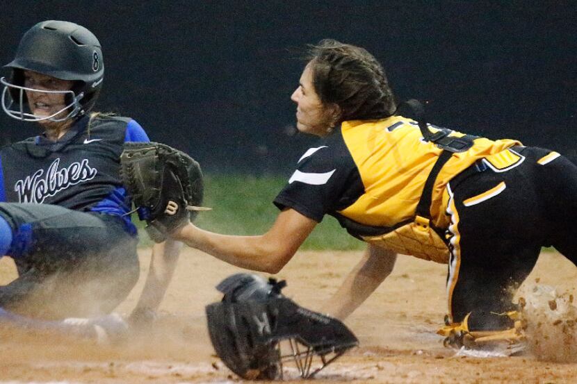 Plano West base runner Madi Gray (left) was safe at the plate as the tag from Plano East...