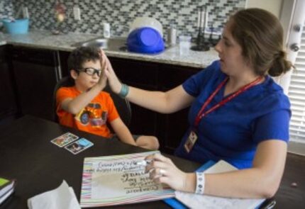  Jacob Casablanca (left) high-fives speech therapist Elizabeth Price during their session...