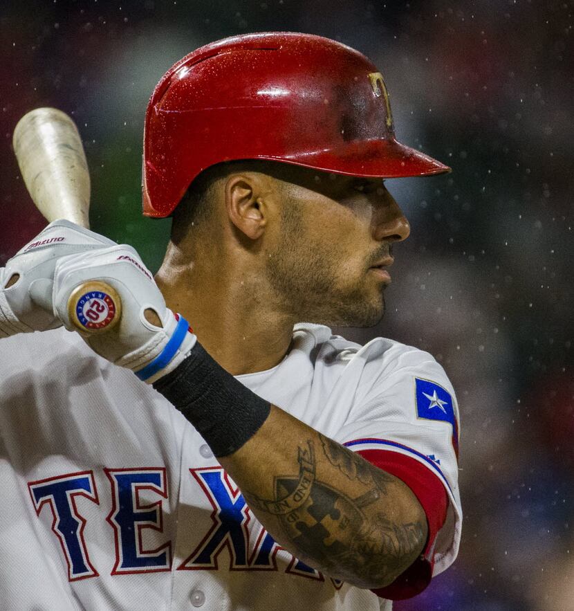 Texas Rangers left fielder Ian Desmond (20) bats in the rain during the eighth inning of...