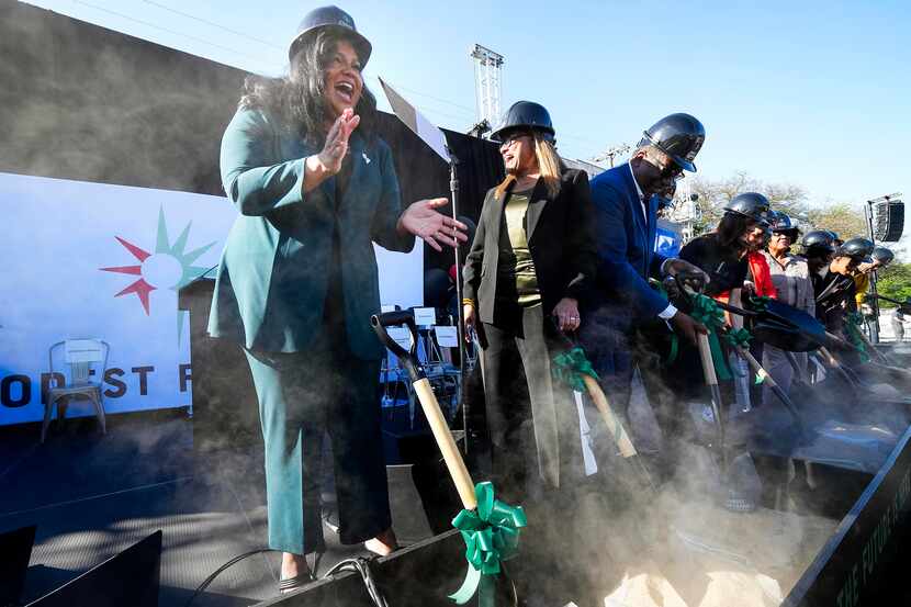 Elizabeth Wattley (left), founder and CEO of Forest Forward, cheers after turning a shovel...
