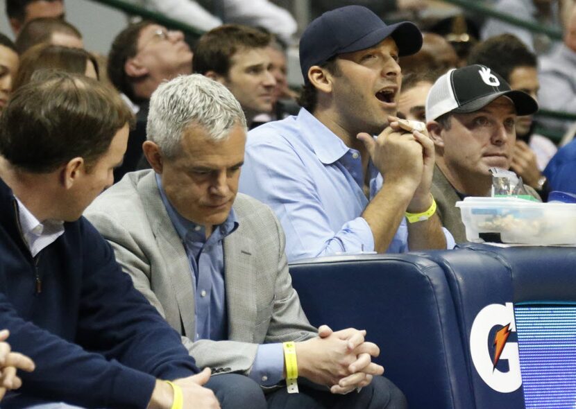 Dallas Cowboys quarterback Tony Romo reacts to the action from his court side seat in the...