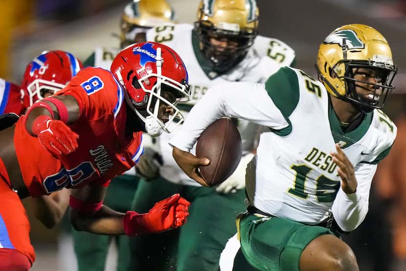 DeSoto quarterback DJ Bailey (15) is brought down by Duncanville edge rusher Colin Simmons...