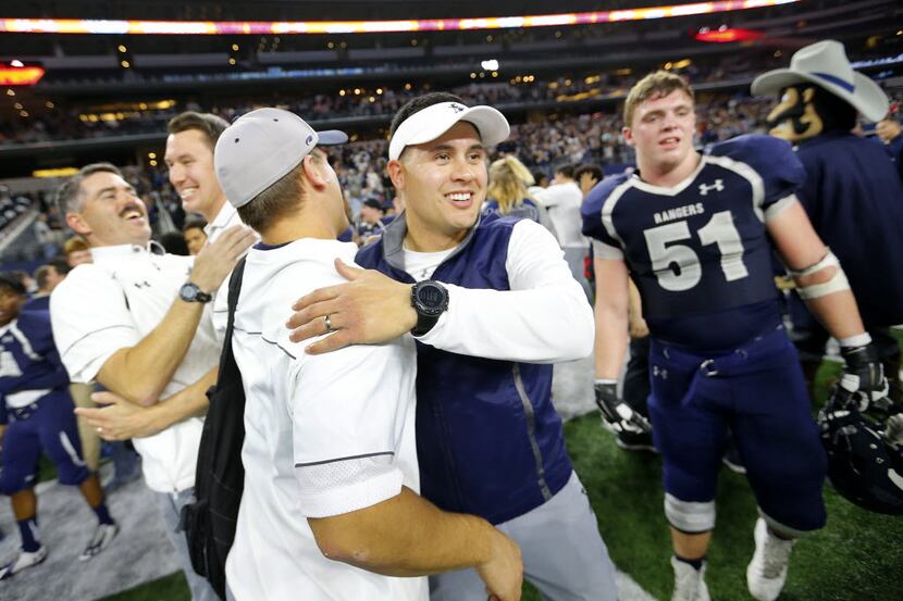 Frisco Lone Star head coach Jeff Raybirn (center, facing) celebrates with his coaches after...