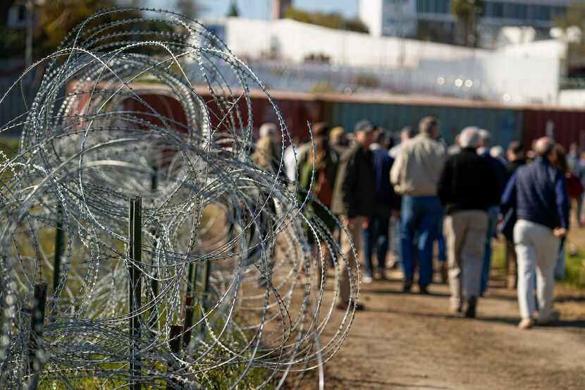 Concertina wire lines the path as members of Congress tour an area near the Texas-Mexico...