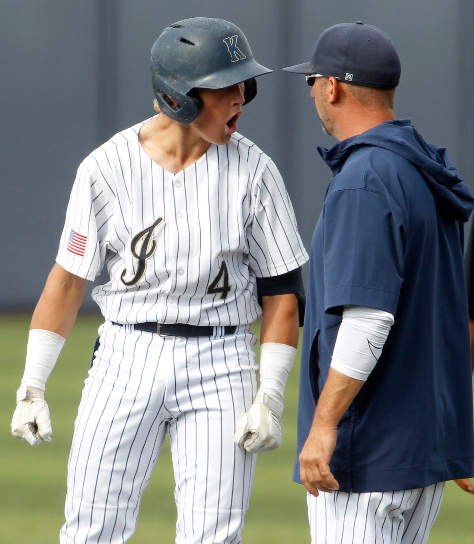 Keller catcher Jake Scheiden (4), left, shares his enthusiasm with assistant coach (at first...