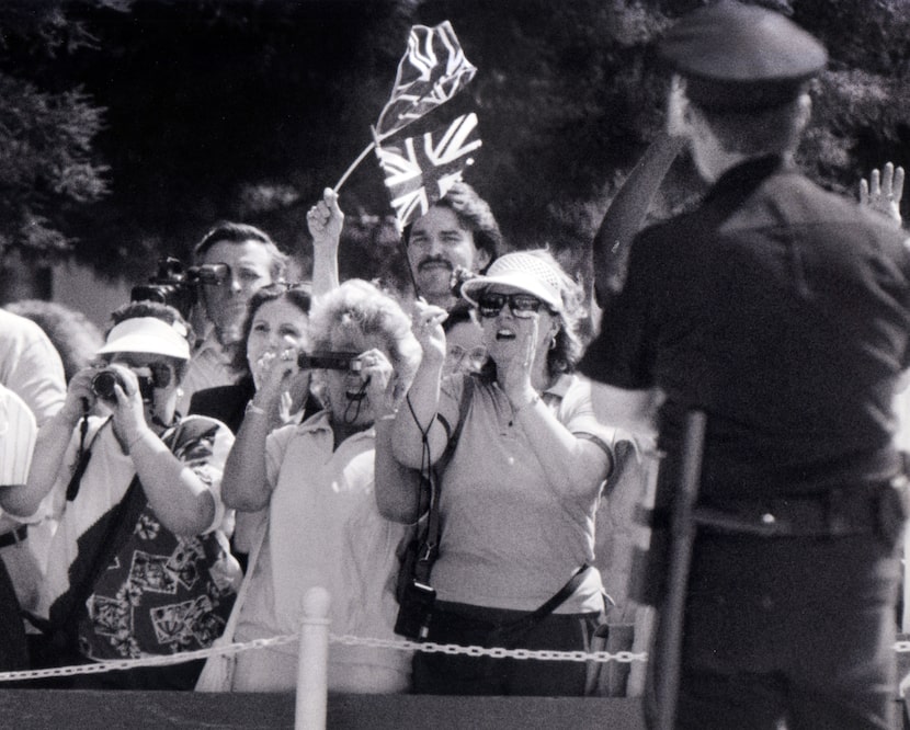 A crowd waits on May 21, 1991, for a glimpse of Queen Elizabeth II as she leaves the Morton...