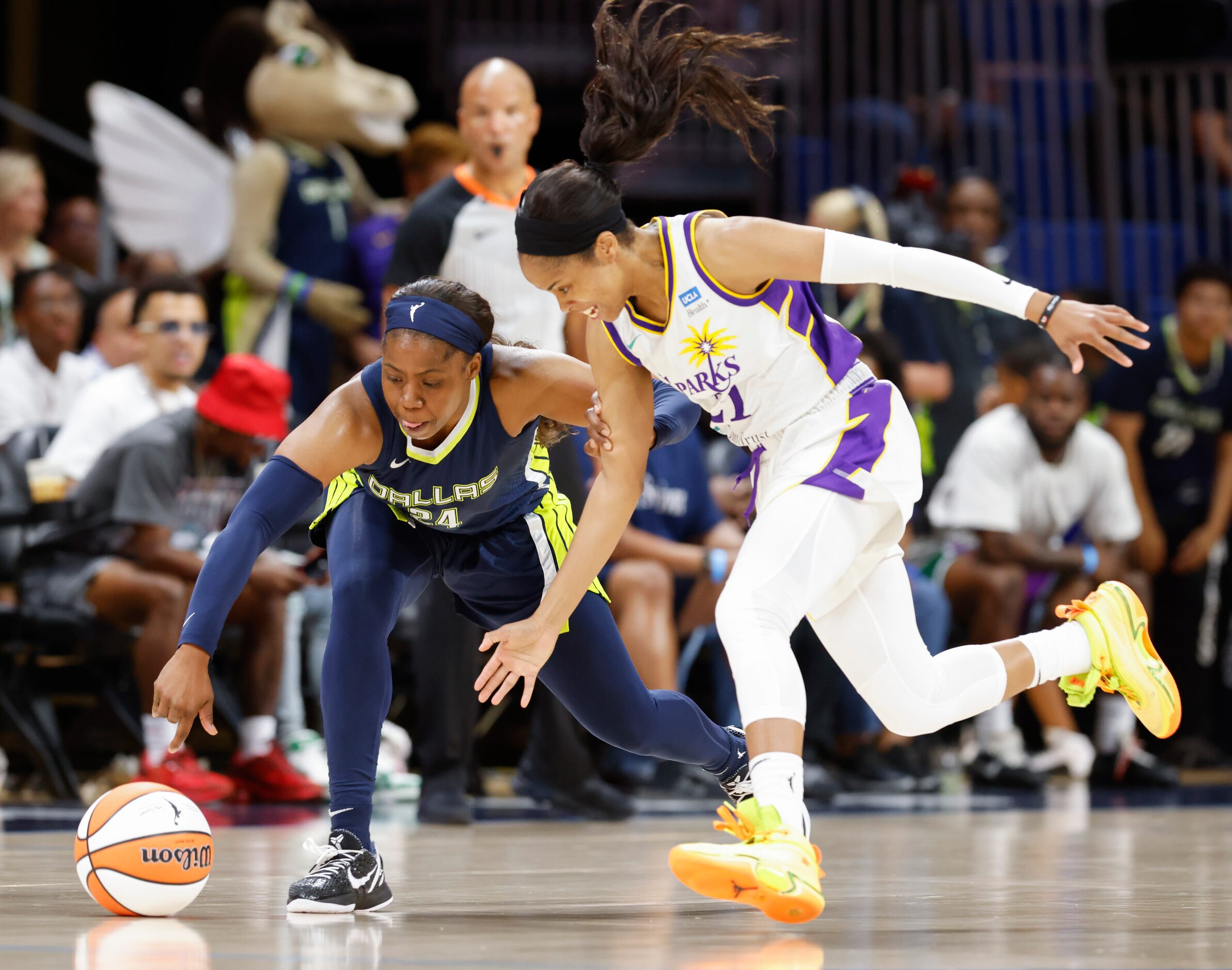 Dallas Wings guard Arike Ogunbowale, left, and Los Angeles Sparks guard Jordin Canada reach...