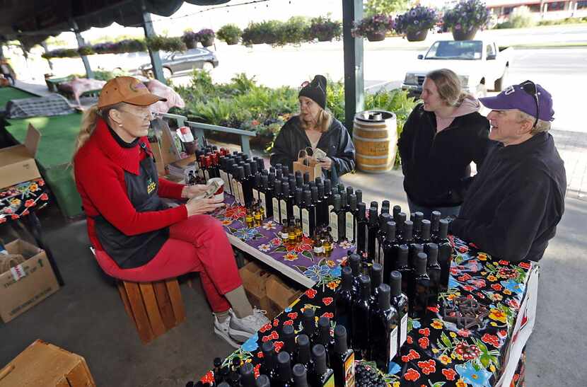 Karen Henry (left) of Dallas, sells olive oil from her ranch in Carrizo Springs to Plano...