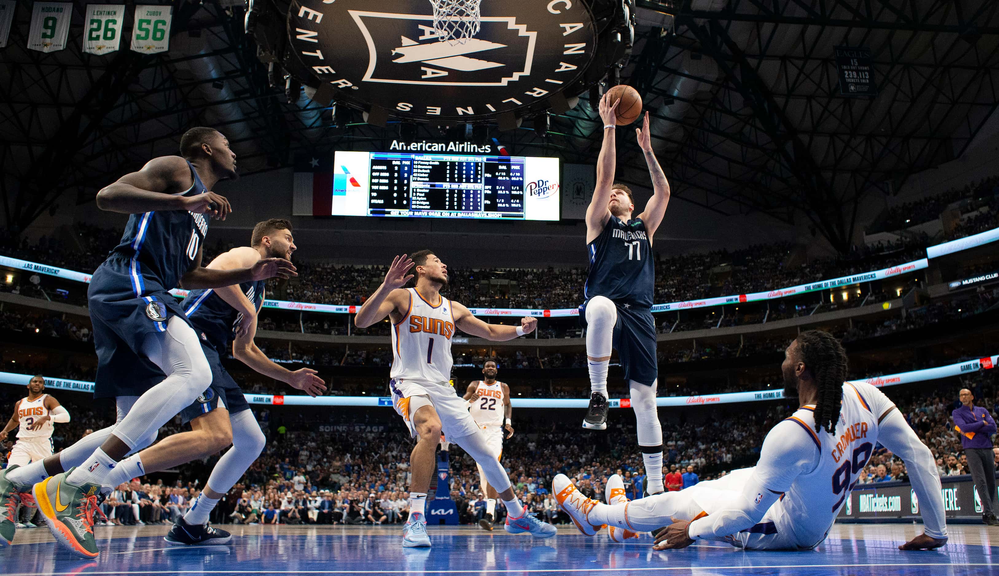 Dallas Mavericks guard Luka Doncic (77) drives the lane and into Phoenix Suns forward Jae...