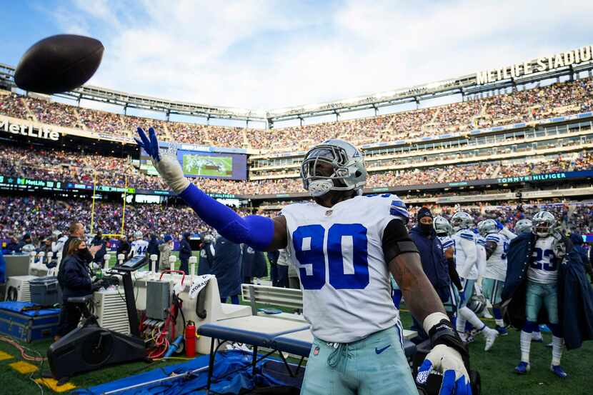 Dallas Cowboys defensive end Demarcus Lawrence (90) tosses a ball to the stands after a New...