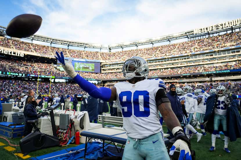 Dallas Cowboys defensive end Demarcus Lawrence (90) tosses a ball to the stands after a New...