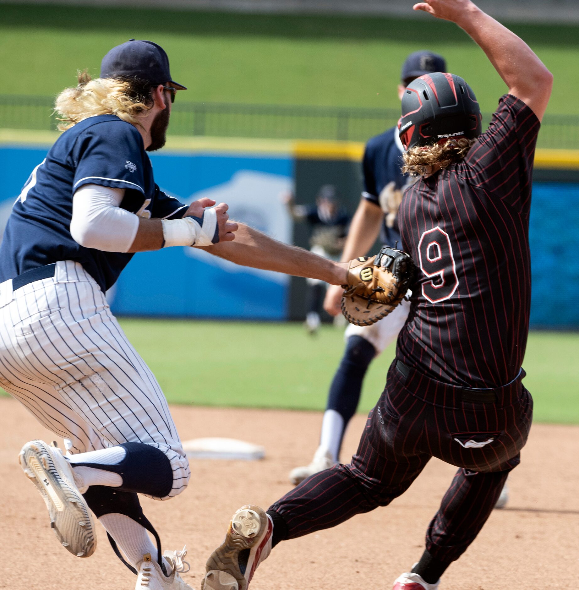 Rockwall-Heath Kevin Bazzell, (9), is tagged out by  Keller Gray Rowlett, (21), after being...