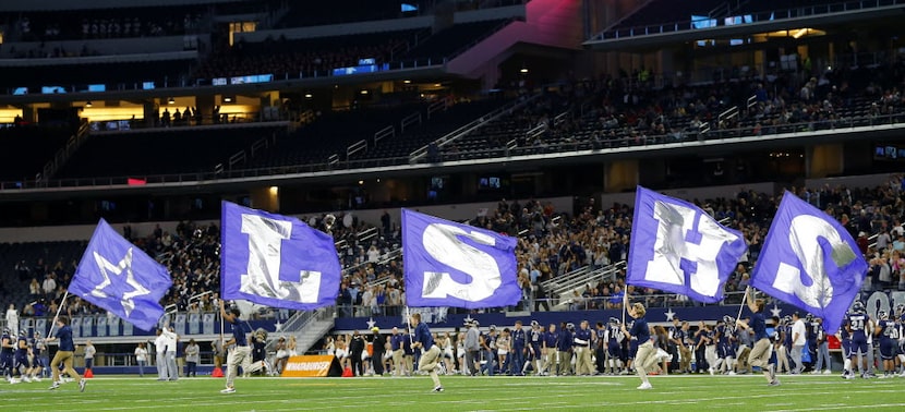 Frisco Lone Star flag team race across the field following a score against Lancaster in the...