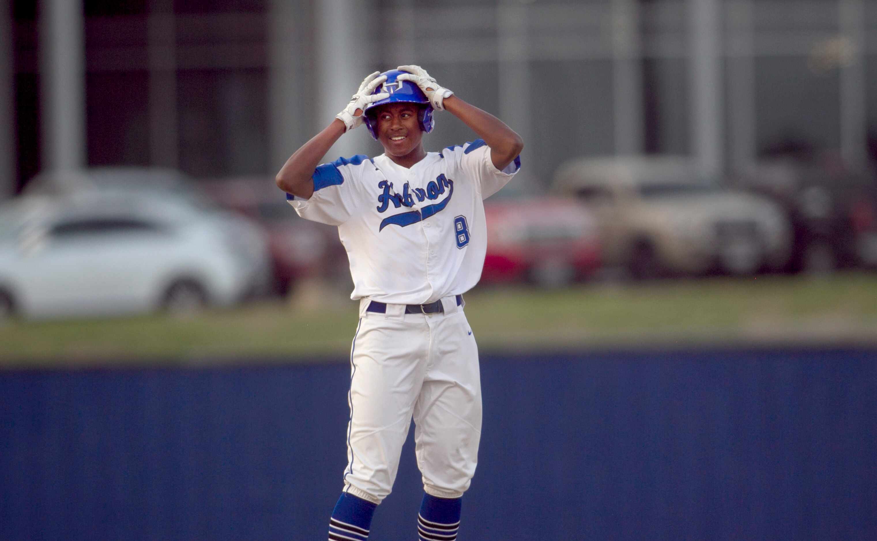 Hebron's Aden Howard (8) reacts to the roar from the Hawks dugout following his stand-up...