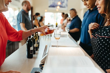 A server pours a glass of wine for patrons