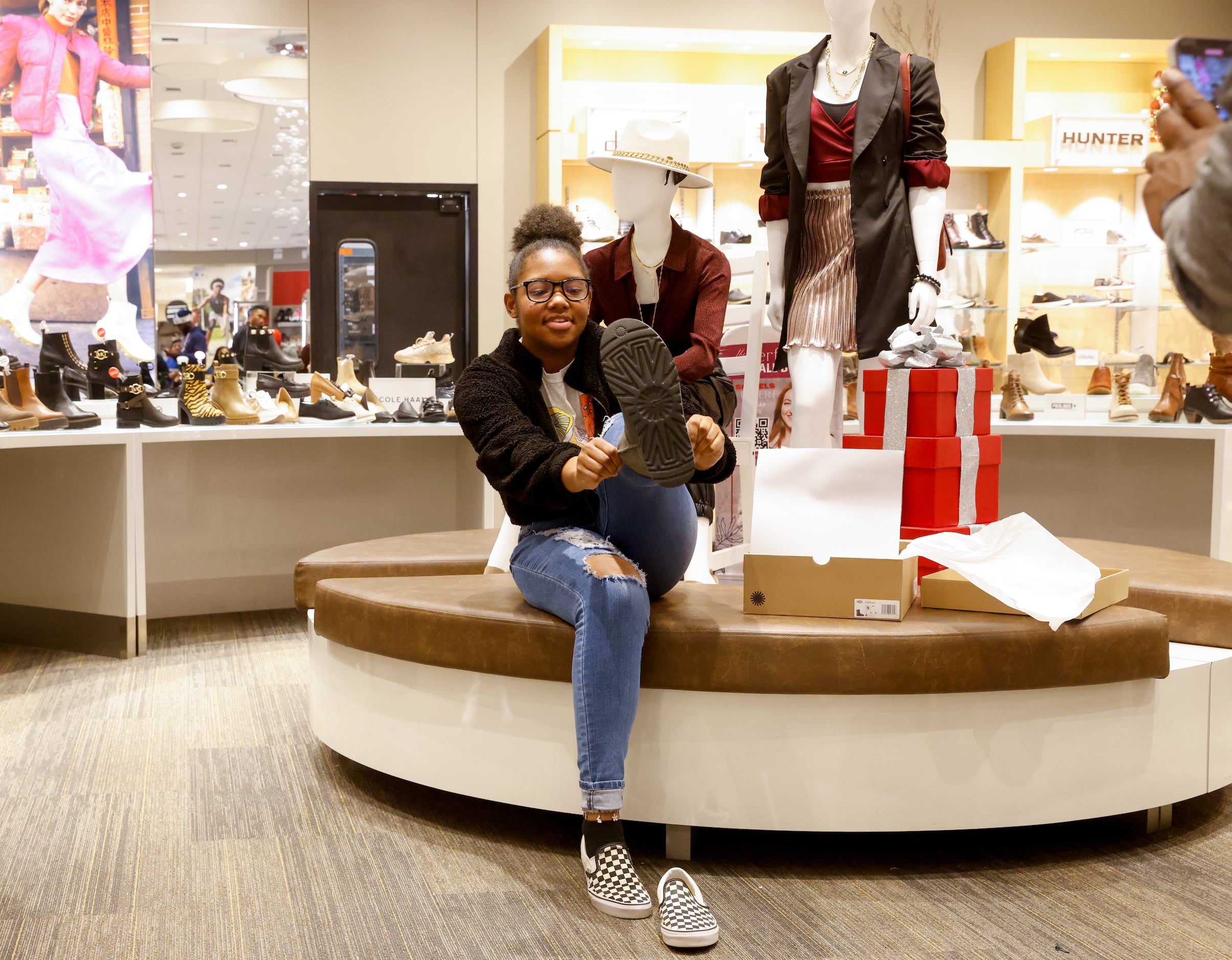 Brooklyn Gilyard, 16, tries on a pair of Ugg boots during a Dallas Mavericks shopping spree...