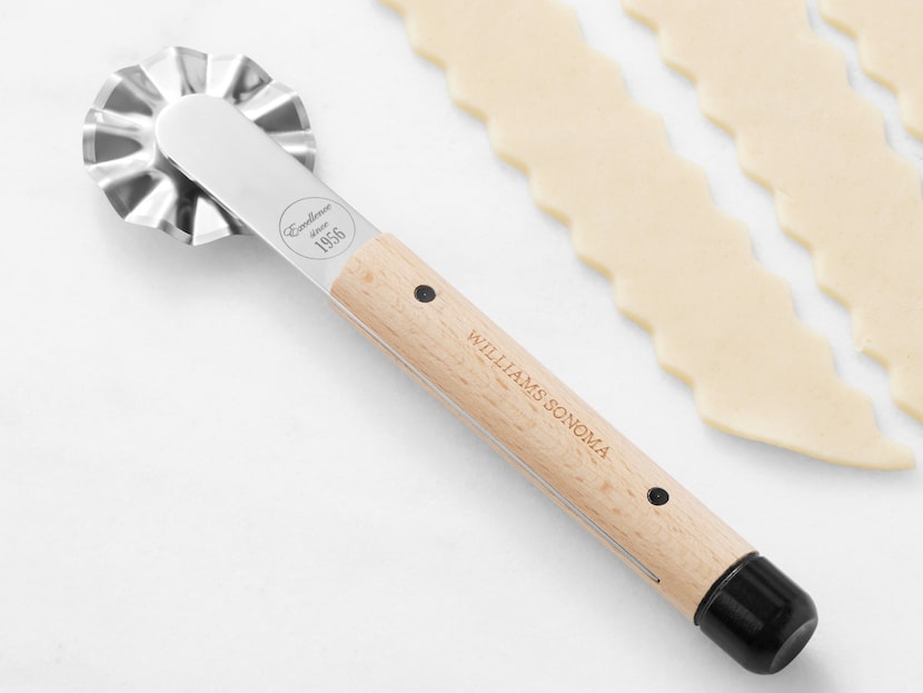 Pastry cutter with wooden handle on a white surface