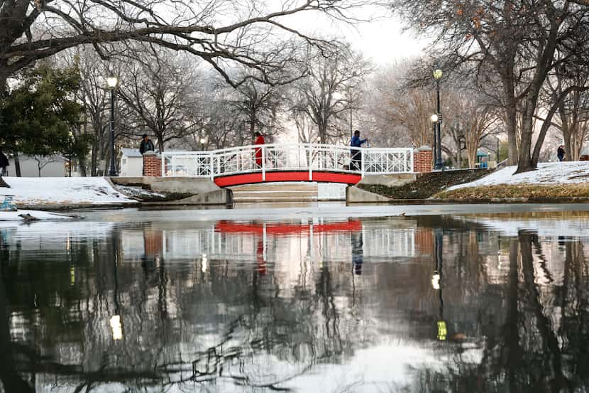People walk over a bridge on Friday, Feb. 4, 2022 in Plano, TX, a day after a winter storm...