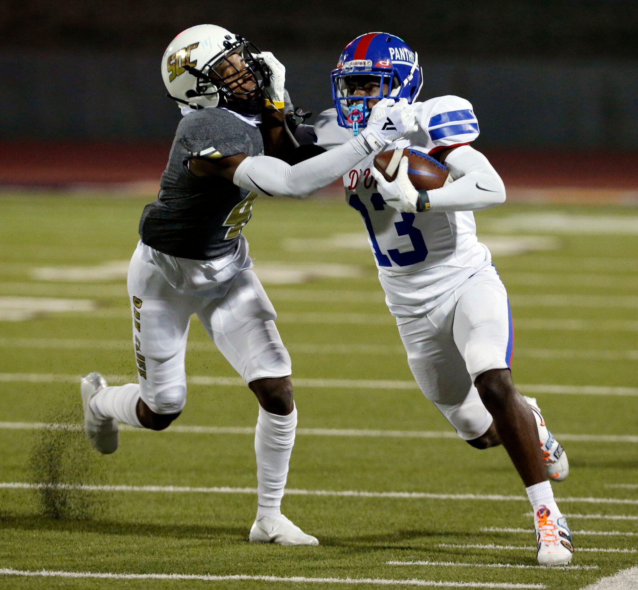 Duncanville’s Roderick Daniels, Jr. (13) straight arms South Oak Cliff’s Malik Muhammad (4)...