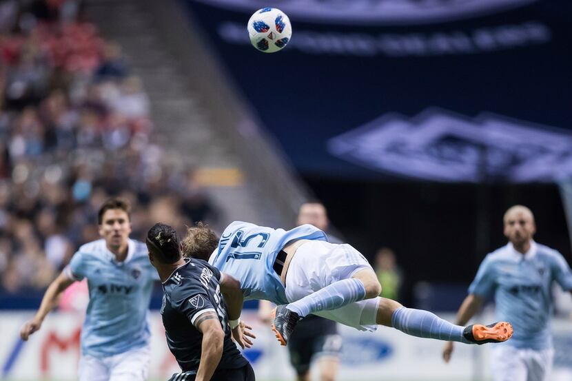Sporting Kansas City's Seth Sinovic (15) falls to the ground after vying for the ball...