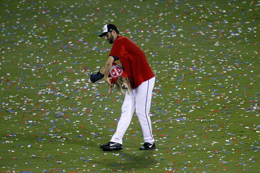 Texas Rangers pitcher Dustin Nippert plays with his daughter amongst the confetti-filled...