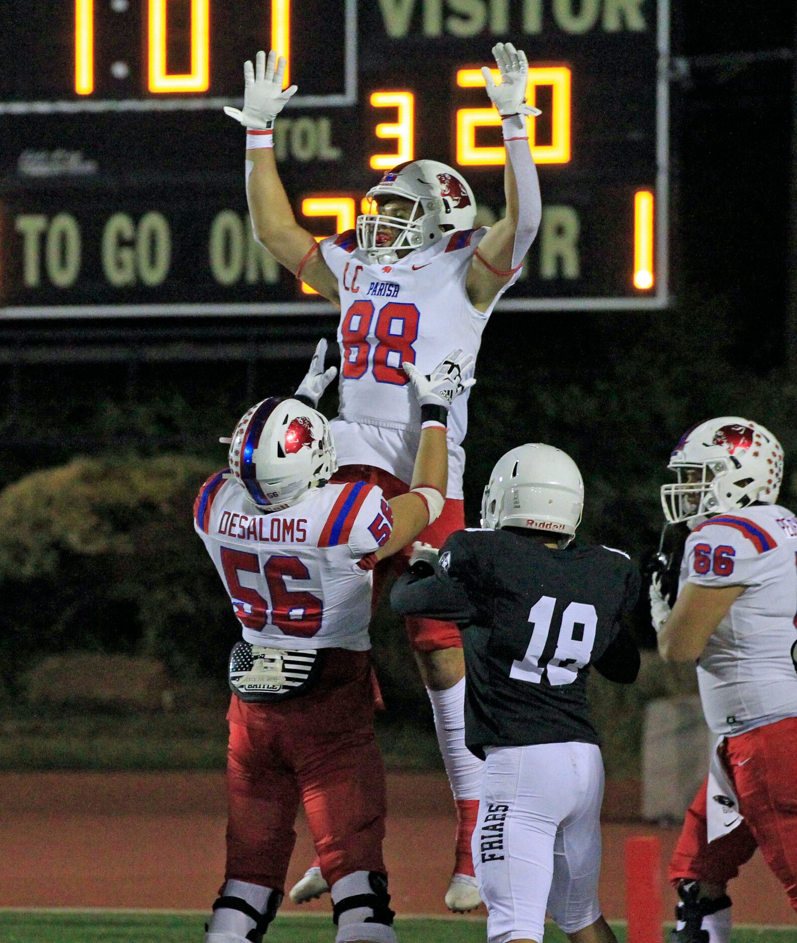 Pariah Episcopal’s Tre Williams (88) is held aloft by teammate Elliot Desaloms (56) after...