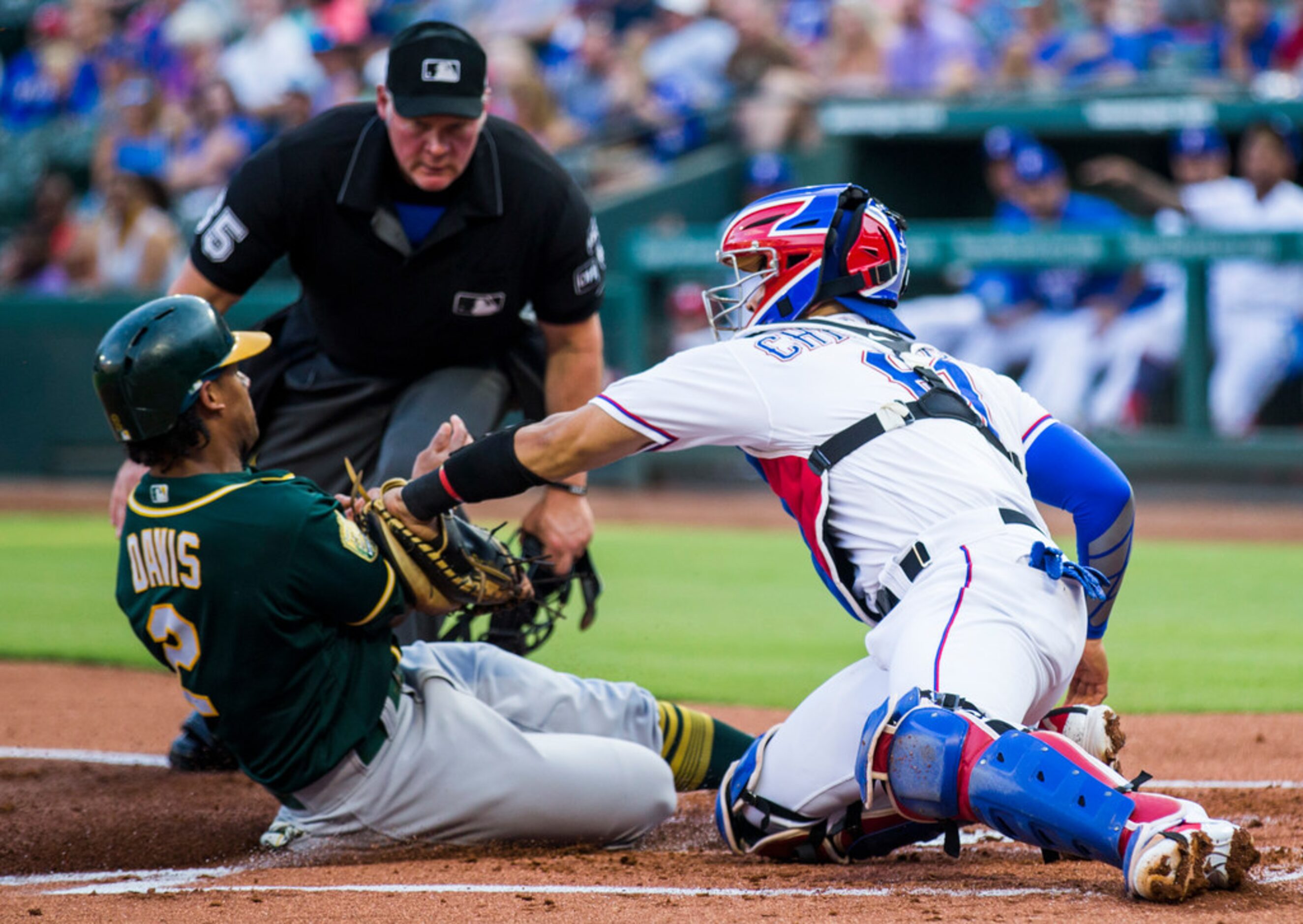 Texas Rangers catcher Robinson Chirinos (61) tags out Oakland Athletics left fielder Khris...