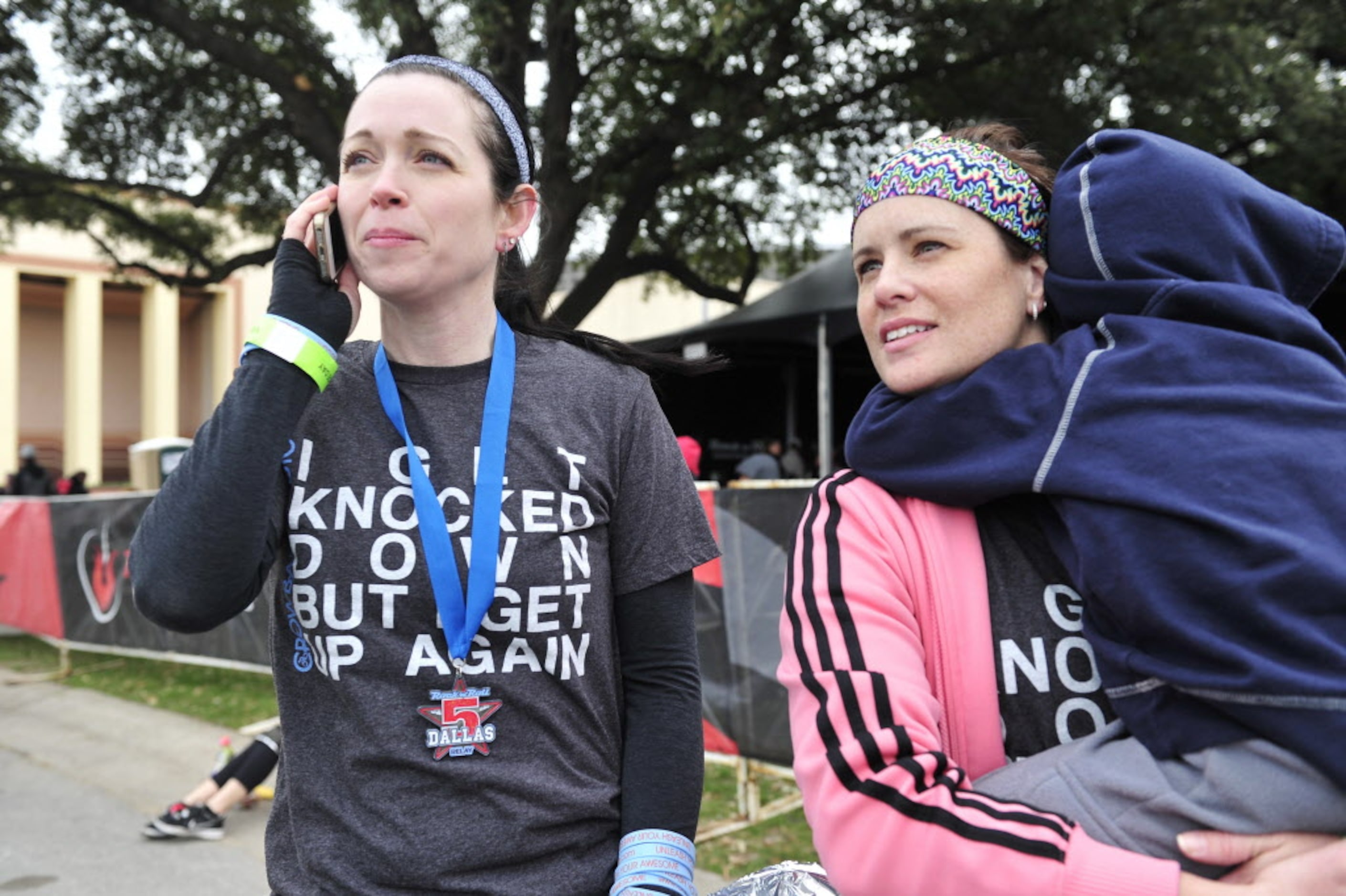 Karen Soltero (left) talks to her mother on the phone as she waits with her friend and relay...