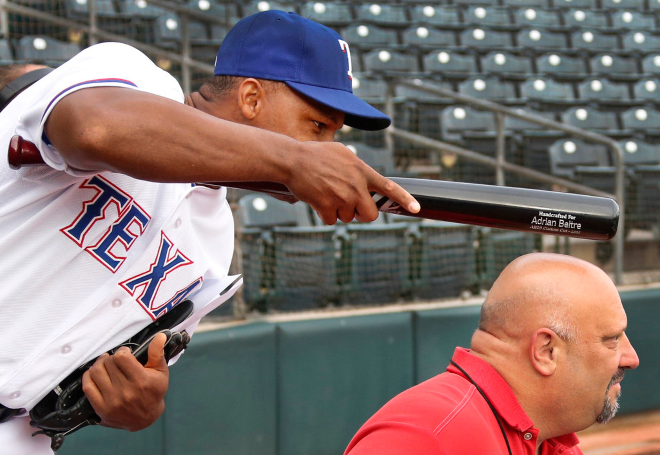 Texas third baseman Adrian Beltre tries to distract a video interview by tapping DMN...