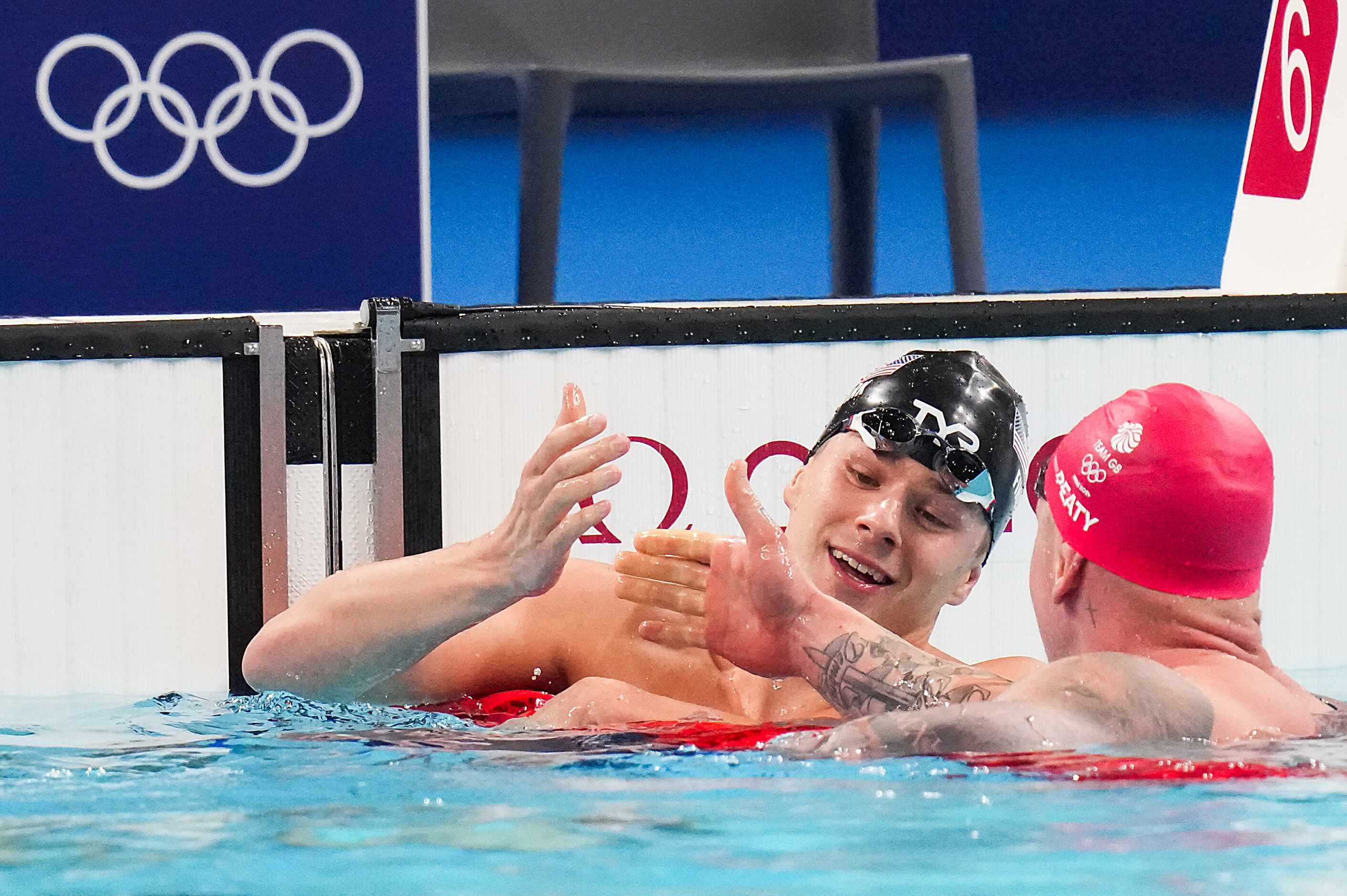 Nic Fink of the United States (facing) celebrates with Adam Peaty of Britain after they tied...