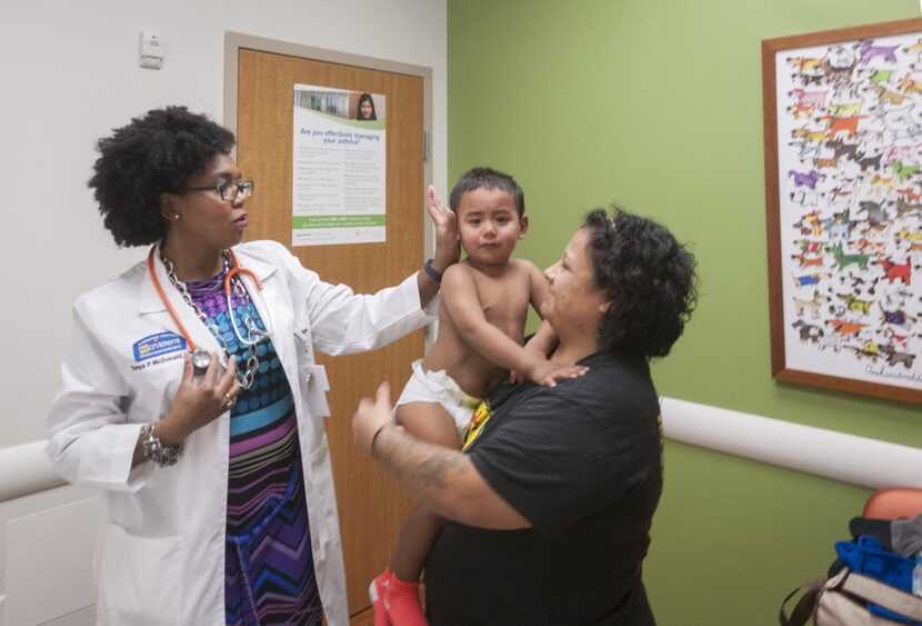 Dr. Tonya McDonald, left, a pediatrician at My Children's Clinic in South Dallas, performs a...