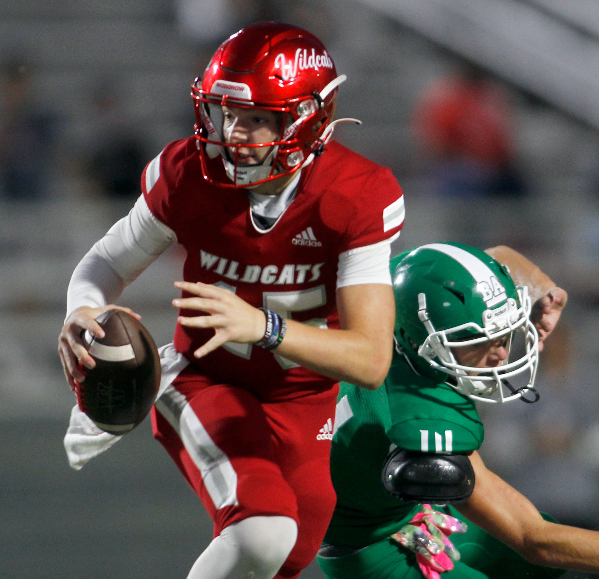 Dallas Woodrow Wilson quarterback Cam McGuire (15) scrambles past the defensive pursuit of...