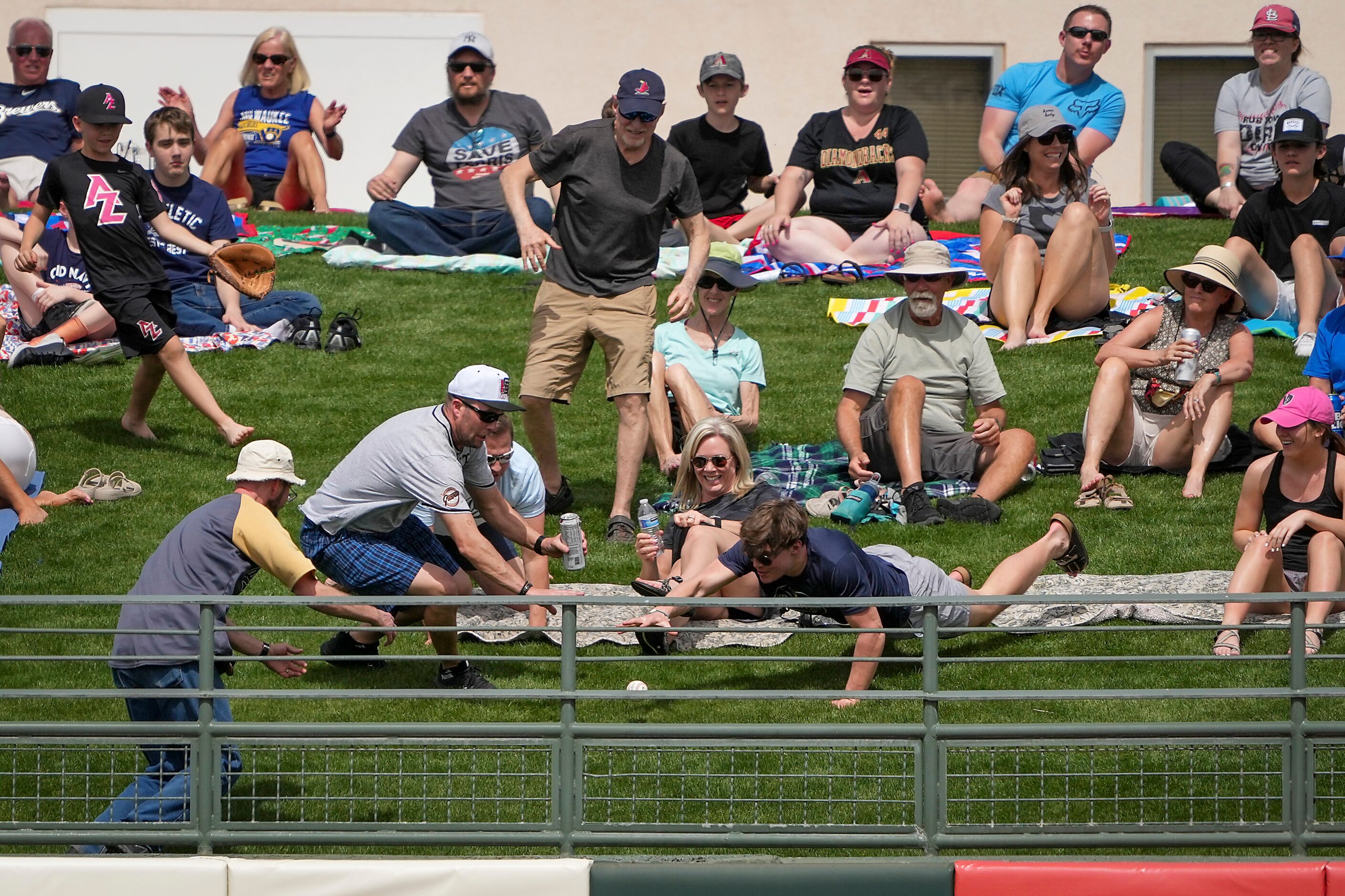 Fand on the outfield berm scramble for a home run ball off the bat of Milwaukee Brewers...