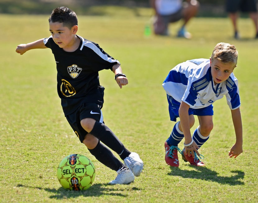 Diego Baylon, left, of PST Attack 2012, moves the ball forward passed a Texas Chaos 2011...