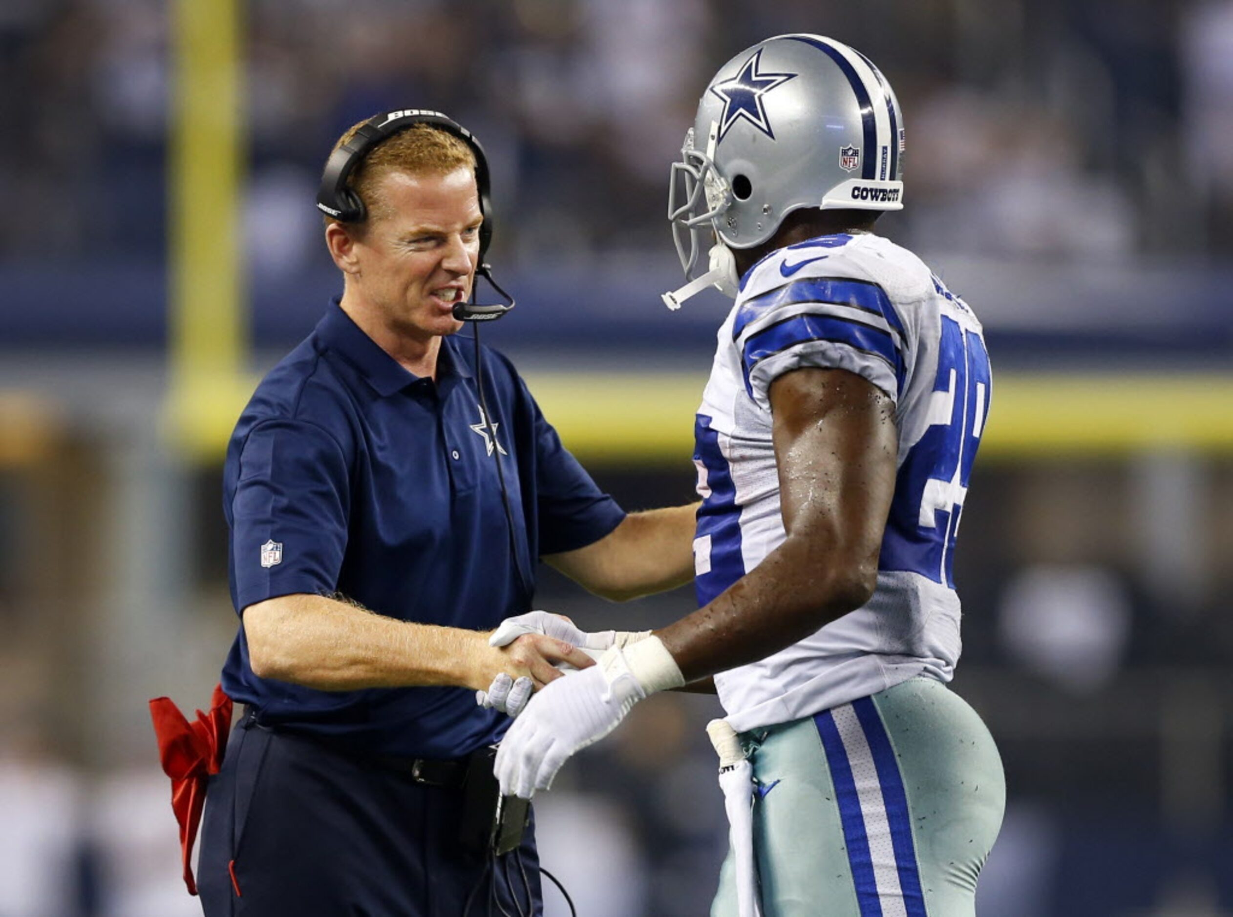 Dallas Cowboys head coach Jason Garrett gives a firm handshake to running back DeMarco...