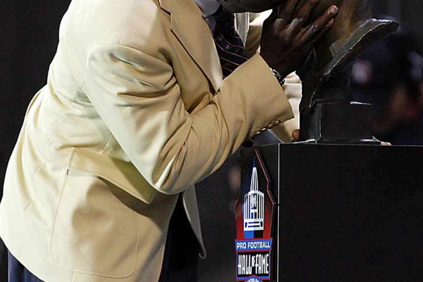 Former Dallas Cowboys Michael Irvin kisses his bust in reaction to seeing his bust unveiled...