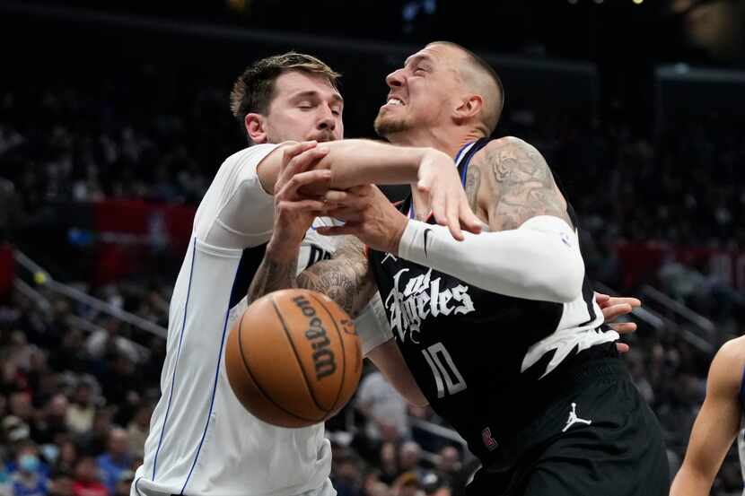 Dallas Mavericks' Luka Doncic, left, knocks the ball out of the hands of Los Angeles...