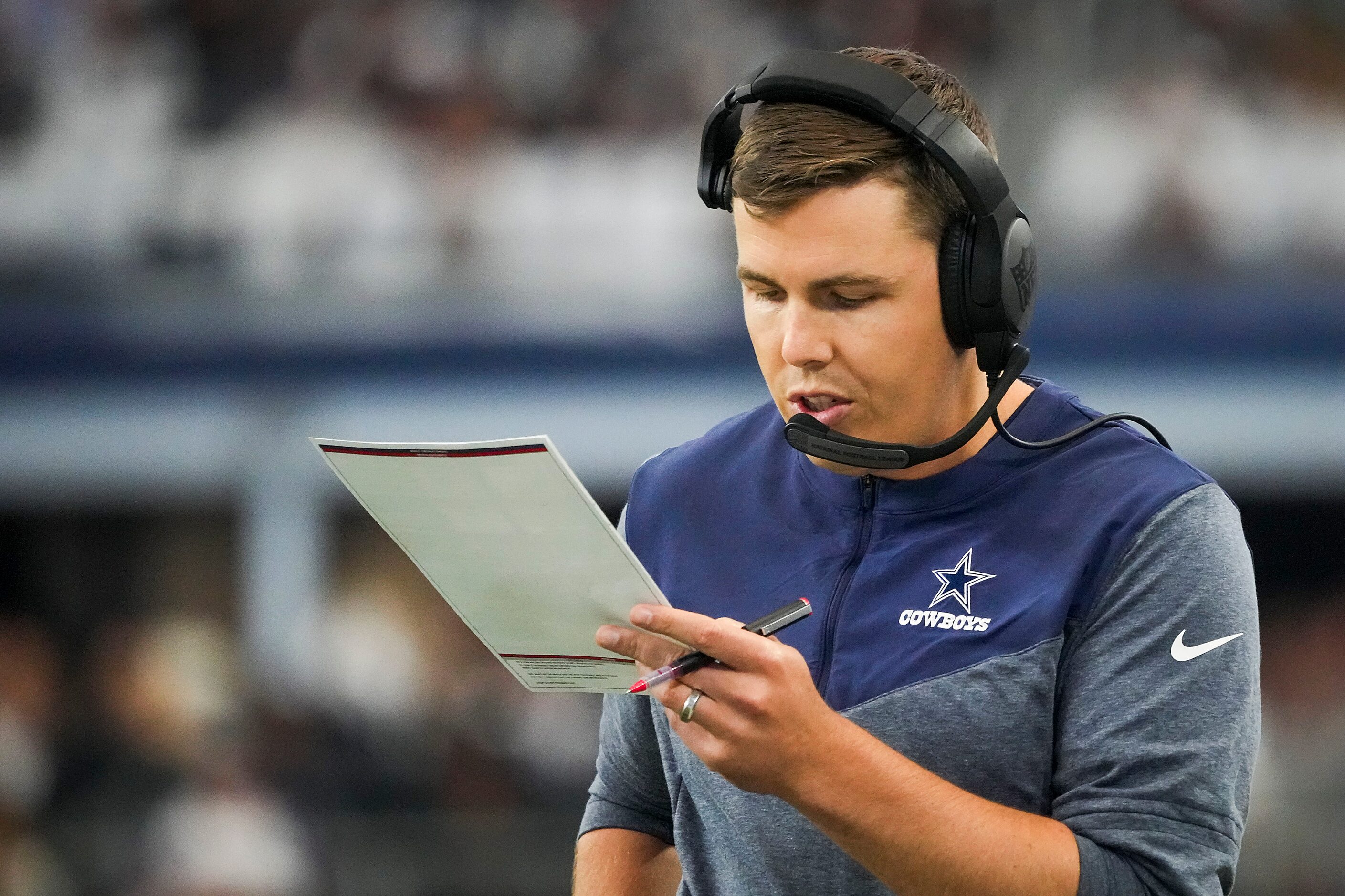 Dallas Cowboys offensive coordinator Kellen Moore works on the sidelines during the first...